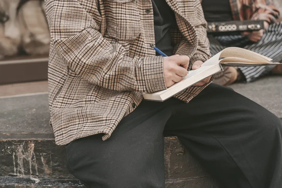 An open notebook and pen on a wooden desk