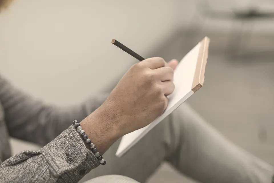 Writing by hand in a notebook