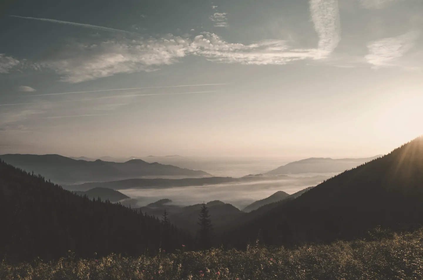 Sunrise over a fog-filled mountain valley